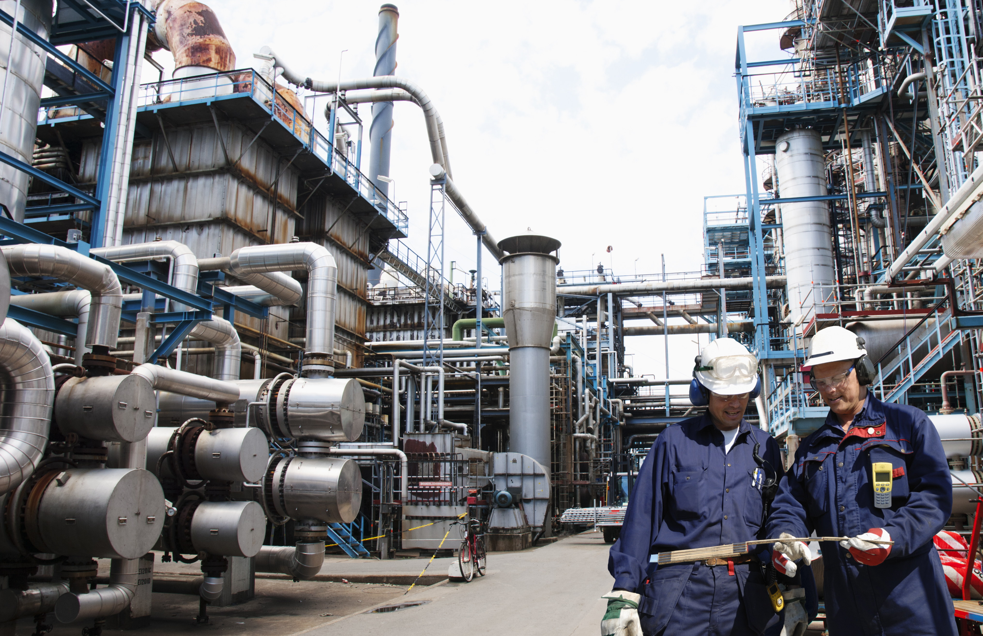 two oil and gas workers inside large refinery, oil and gas.