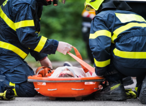 firefighters putting a motorcycle rider onto a carry board